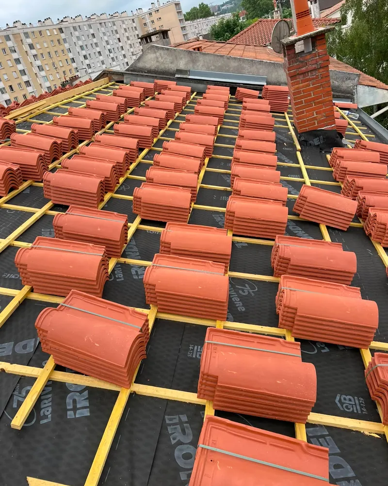Tuiles neuves réparties sur les liteaux avant pose, chantier de couverture à Tarbes
